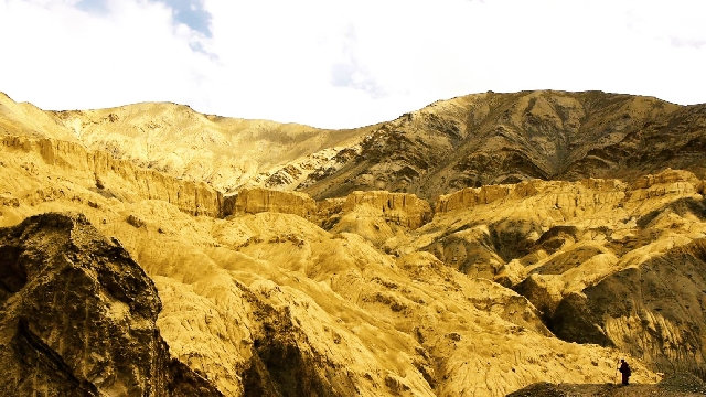 Das Bild zeigt den tibetischen Pilger winzig klein vor einer Himalaya-Berglandschaft.